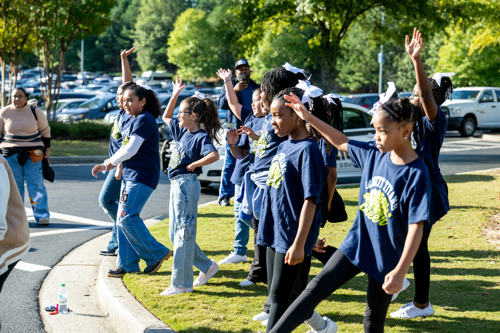 photo of kids in matching shirts cheering on lawn